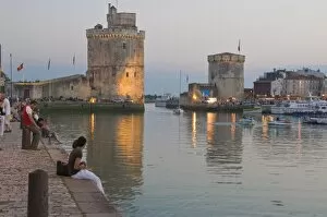 Couple sitting on the harbour-side at La Rochelle, Charente-Maritime, France, Europe