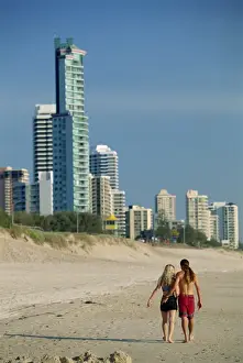 Queens Land Prints: Couple walking along beach at the resort of Surfers Paradise on the Gold Coast of Queensland