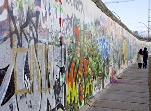 Exclusion Prints: Couple walking along the East Side Gallery Berlin Wall mural, Berlin, Germany, Europe