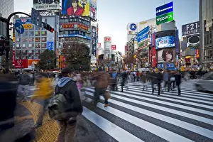 Crowds crossing the famous Shibuya Crossing intersection at the centre of Shibuyas fashionable shopping and entertainment district, Shibuya, Tokyo