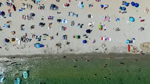 Swimming Prints: Crowds enjoy a sunny day at Legenese cove beach in Carnac