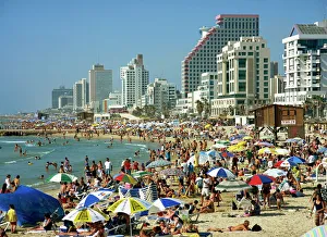 Crowds of tourists on the beach with tall seafront buildings, at Tel Aviv Crowds of tourists on the beach with tall seafront buildings, at Tel Aviv