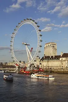 Ferris Wheels Prints: Cruise boats sail past County Hall and the London Eye on the South Bank of the River Thames