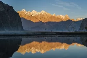 The crystal clear Shyok River creates a mirror image of sunrise on Karakoram peaks
