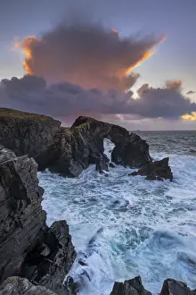 Cumulonimbus Cloud over Stac a Phris Natural Sea Arch at sunset, near Shawbost