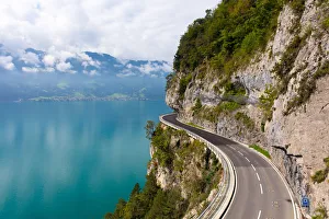 Bern Prints: A curved road built into the side of a mountain next to Lake Thun