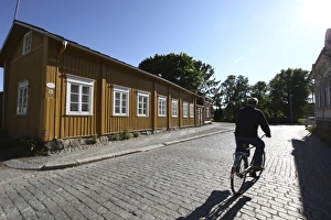 Cyclist Prints: Cyclist on cobblestone street, Old Town, Rauma, Satakunta, Finland, Scandinavia, Europe
