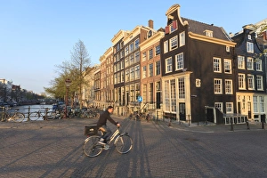 Bicycles Prints: Cyclist crossing a bridge over Keizersgracht Canal, Amsterdam, Netherlands, Europe