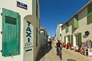 Images Dated 15th August 2009: Cyclist on Rue Lamathe in the islands principal western town, Ars en Re, Ile de Re