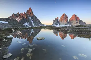 Dawn illuminates the Three Peaks and Mount Paterno reflected in the lake, Sesto