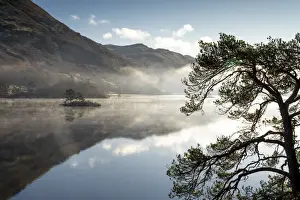 Dawn light and transient sunlit mist over Wall Holm Island on Ullswater, Lake District