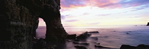 Dawn view over North Sea from beach at Marsden Bay, showing natural rock arch in Marsden Rock