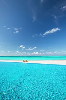 Swimming Pools Prints: Deck chairs and infinity pool over amazing tropical lagoon