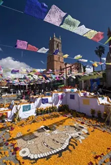 Dangling Prints: Decorations for the Day of the Dead festival with Iglesia de San Rafael in the background