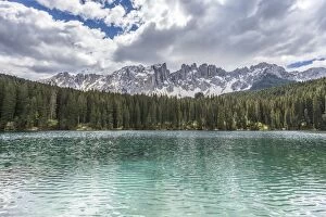 The still deep water of Lake Carezza surrounded by the picturesque frame of the Dolomites