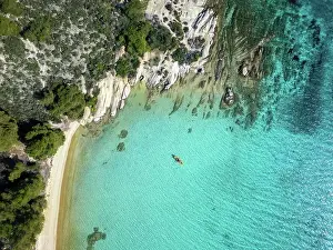 Kayaking Prints: Diaporos island with wild beaches and a kayak on the turquoise water