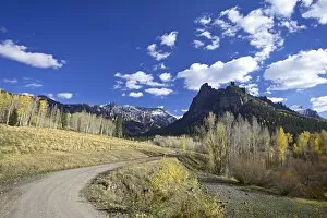 Dirt mountain road with aspens and cottonwoods in fall color
