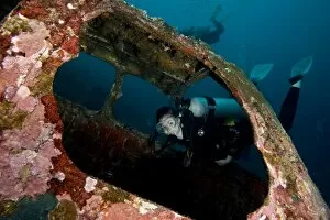 Images Dated 27th December 2011: Diver entering the front window of a four seater plane wreck, Philippines, Southeast Asia, Asia