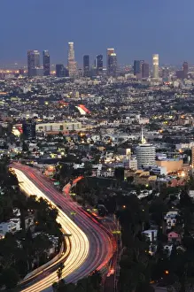 Downtown district skyscrapers and car lights on a city highway