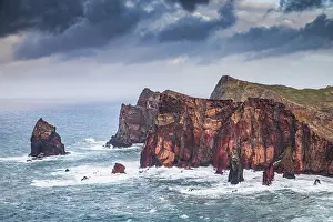 Madeira Prints: Dramatic coastline view with rocks showing colors near the sea in Madeira Portugal during cloudy weather