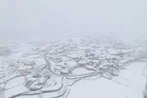 Drone aerial view of a road and remote village covered with snow in Vila Real, Norte