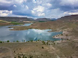 Cappadocia Prints: Drone view of Akkoy dam lake showing reflection on water in Cappadocia region of Turkey with hills