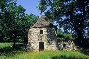Grassland Prints: Dry stone hut in Quercy area surrounded by trees and grass in Midi-Pyrenees region of France
