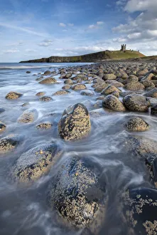 Dunstanburgh Castle from the rocky shores of Embleton Bay, Northumberland, England