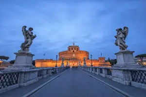 Dusk on the ancient palace of Castel Sant Angelo with statues of angels on the bridge