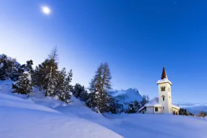 Engadine Prints: Dusk over Chiesa Bianca in the snowy landscape lit by moon, Maloja, Bregaglia Valley