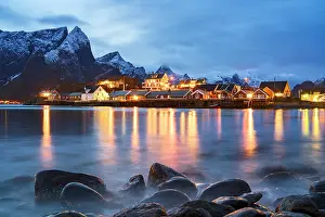 Settlement Prints: Dusk lights over fishing village with reflections in water and mountains in Lofoten Islands