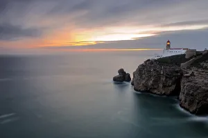 Portuguese Prints: Dusk lights up the lighthouse overlooking the Atlantic Ocean, Cabo De Sao Vicente