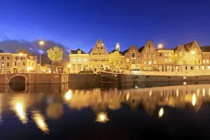 The Netherlands Prints: Dusk lights on typical houses and bridge reflected in a canal of the River Spaarne