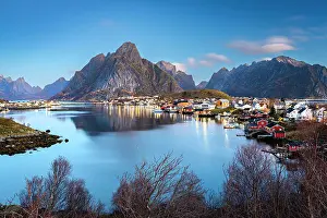 Sakrisoy Prints: Dusk over majestic Olstind mountain overlooking the iconic harbor of the fishing village of Reine