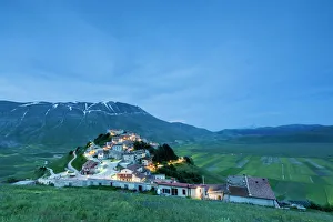 Meadow Prints: Dusk on the medieval village surrounded by green fields, Castelluccio di Norcia