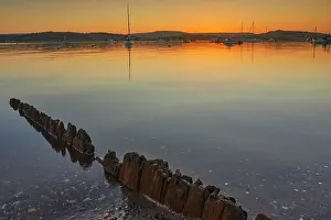 Silhouettes Prints: Dusk settles over the estuary of the River Exe at Exmouth with boats scattered across the water under a colorful sky