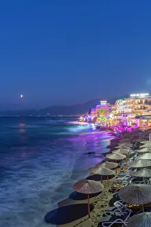 Recreational Prints: Dusk view of beach and town overlooking the sea in Limenas Chersonisou