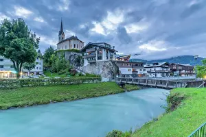 Riverside Prints: Dusk view of church and river in Kaprun with summer scenery in background