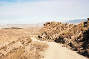 Granada Prints: Dusty desert track winds through barren land in the Desierto de Gorafe near Granada