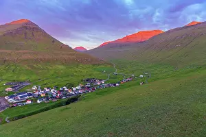 House Exterior Prints: Early morning on Gjogv village with the mountain peaks lit by the sun