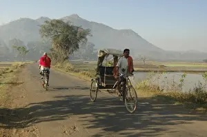 Early morning rickshaw wallahs pass each other in rural countryside near Baliguda