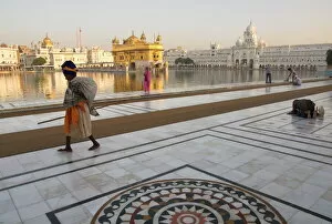 National Famous Place Collection: Elderly Sikh pilgrim with bundle and stick walking around holy pool