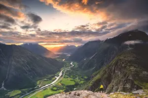 More Og Romsdal Prints: Elevated view of man standing on Romsdalseggen ridge admiring Rauma valley during sunset