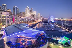 Seattle Prints: Elevated view of Seattle skyline and restaurants in Bell Harbour Marina at dusk