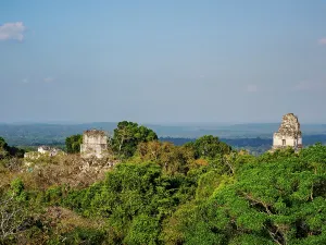 Relics Prints: Elevated view of Temples I and II at Tikal surrounded by forest and distant hills in Guatemala