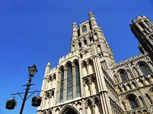 Lamp Prints: Ely Cathedral stands tall against a clear blue sky with unique architectural details and surrounding elements visible