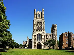 Cambridgeshire Prints: Ely Cathedral stands tall in the sunny sky above the green field in Ely