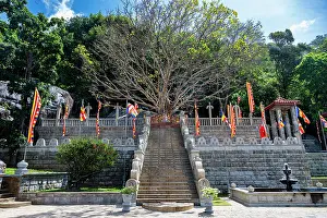 Sculptures Prints: Entrance to Dambulla Cave Temple in Sri Lanka with steps and flags present
