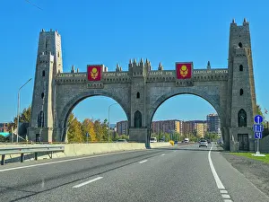 Streets Prints: Entrance gate to Magas shows architectural design details and national flags with clear skies overhead in Ingushetia