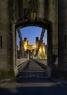 North Wales Prints: Entrance to Telford's Conwy Suspension Bridge and Conwy Castle at night